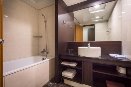 台中市双星大饭店的一间带水槽、浴缸和镜子的浴室