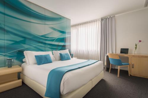 马德里奥斯卡媒介酒店的配有一张床和一张书桌的酒店客房