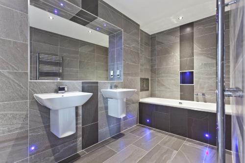 安布尔塞德钻石精品仅限成人旅馆的浴室配有盥洗盆、卫生间和浴缸。