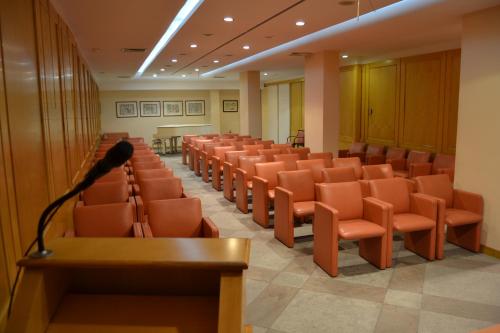 兰恰诺Hotel Excelsior的一个带橙色椅子和麦克风的讲座大厅