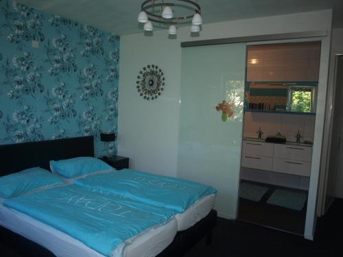 栋堡B&B De Domburcht的一间卧室配有一张带蓝色棉被的床