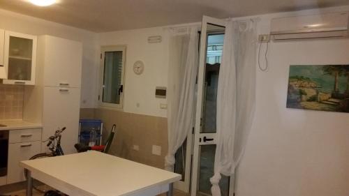丽都玛里尼Lido Marini的厨房配有桌子和带窗帘的窗户