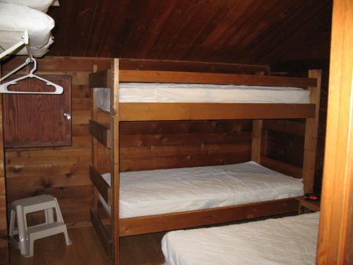 Freewood Acres森林与湖露营度假村18号小屋的木墙客房的两张双层床