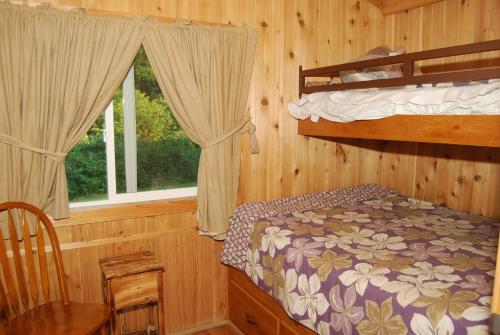 西塞德Seaside Camping Resort Cottage 11的一间卧室设有两张双层床和一扇窗户。