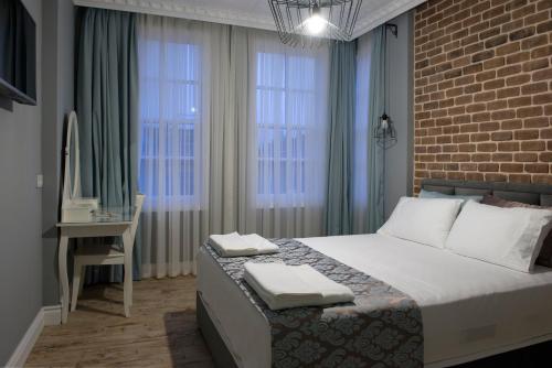 安塔利亚老城月神酒店的卧室配有一张床、一张书桌和窗户。