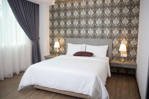雪邦克拉希克酒店的卧室配有白色的床和两盏灯。