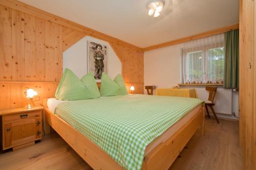 蒂罗尔州奥伯恩多夫Haus Waldrand的一间卧室配有一张带绿色和白色棉被的床