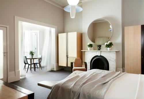 悉尼悉尼美杜莎酒店的一间卧室配有一张床、镜子和一张桌子