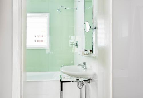悉尼悉尼美杜莎酒店的白色的浴室设有水槽和淋浴。
