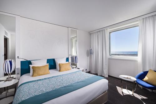 马赛马赛欧洲地中海金色郁金香酒店的酒店客房设有一张床和一个大窗户