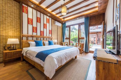 丽江丽江悦途精品度假酒店的一间卧室配有一张大床和电视