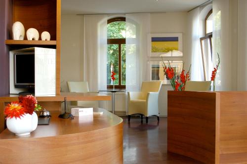 魏玛包豪斯弗斯特霍夫公寓式酒店&酒店的厨房以及带桌椅的起居室。