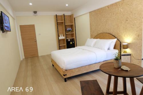 曼谷69区（廊曼机场）公寓式酒店的卧室配有白色的床和桌子