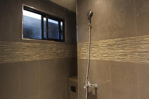 垦丁大街海都旅店三馆的带窗户的浴室内的淋浴间