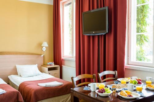 坦佩雷威乐酒店的酒店客房设有带食物的桌子和电视。