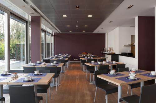 伊泽海姆伊泽赫姆公园酒店的用餐室设有桌椅和窗户。