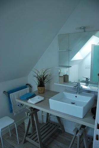 布吕兹Au Detour de Rennes的浴室设有白色水槽和镜子