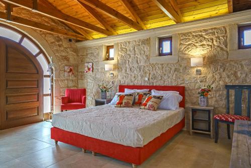 阿斯特里昂Luxury Villa Aria with Pool & Children's Area, 5km to Beach!的一间石墙卧室,配有红色的床
