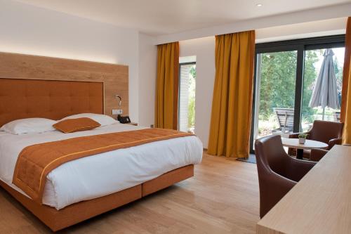阿勒瑟穆瓦魅力酒店的一间卧室配有一张床和一张桌子及椅子