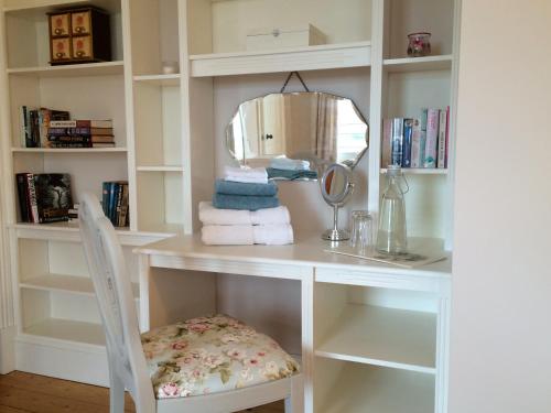 格伦蒂斯Brook Lodge的一张带椅子和镜子的白色书桌