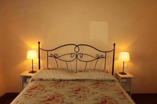蒙特卡蒂尼泰尔梅吉尔迪穆拉旅馆的一间卧室配有一张床,两台桌子上放着两盏灯