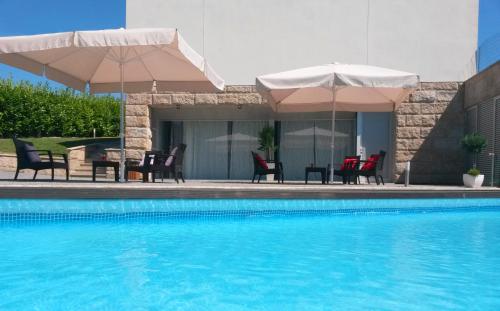 圣托·蒂尔索Equinaturi的游泳池配有椅子和遮阳伞以及桌椅