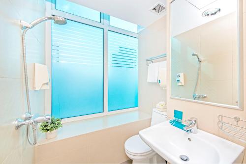 新加坡Hotel 81 Bugis的一间带水槽和卫生间的浴室以及窗户。