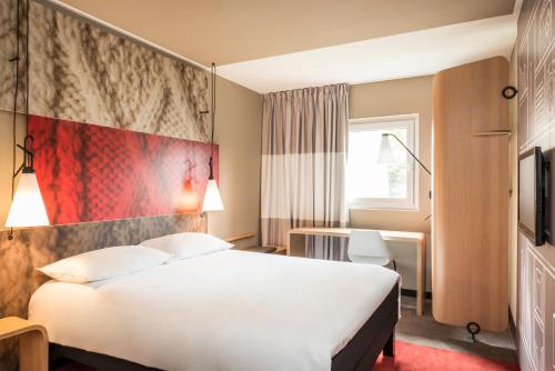 圣路易巴勒米卢斯机场宜必思酒店的酒店客房,设有白色的床和红色的墙壁