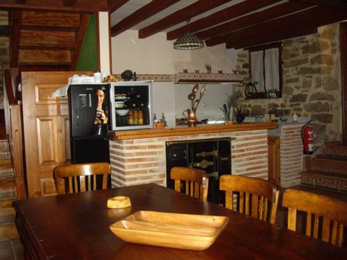 埃斯皮诺萨德洛斯蒙特罗斯Hotel Rural La Casa del Montero的厨房配有木桌、椅子和壁炉