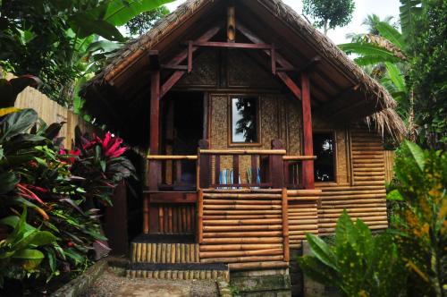 特特巴图绿岛民宿的花园中带阳台的小木房子