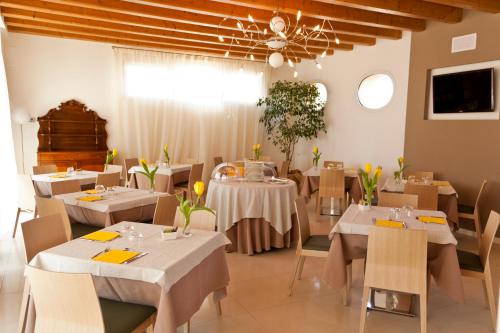 法瓦罗威尼托Agriturismo Ca' Beatrice - Venice Airport的餐厅设有白色的桌椅和天花板