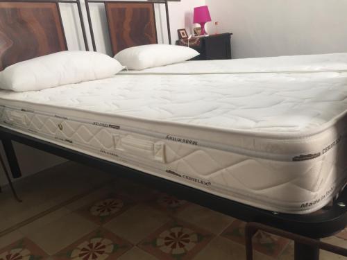 库特罗菲安诺Nel Cuore del Salento的一张床垫,放在一个房间里的床架上