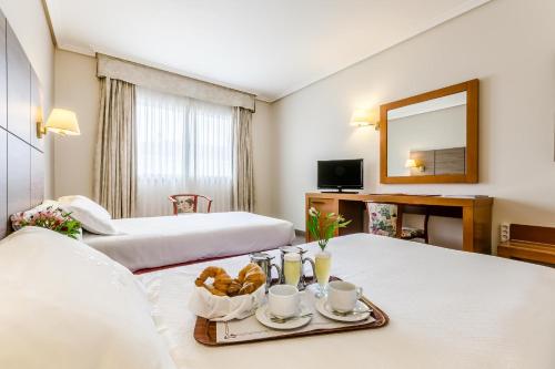 庞特维德拉加利西亚皇宫酒店的酒店客房设有两张床和一盘食物