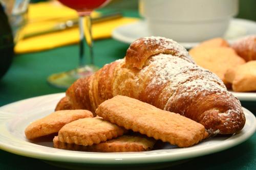 基安奇安诺泰尔梅马提尼酒店的桌上放着羊角面包和饼干的盘子