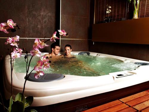 维耶拉Gran Chalet Hotel & Petit Spa的两人坐在浴缸里