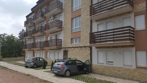 Gornja ToplicaApartment Krstin Banja Vrujci的两辆汽车停在大楼前