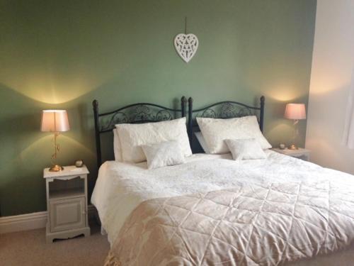 罗斯伯里The Haven的一间卧室配有一张带两盏灯的大型白色床。