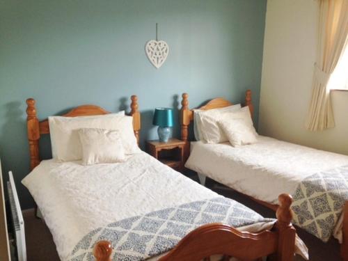 罗斯伯里The Haven的一间卧室配有两张带白色棉被的床
