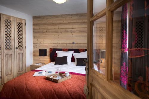 雷加霍斯达哈施CGH Résidences & Spas Les Chalets de Léana的一间卧室设有一张带木墙的大床