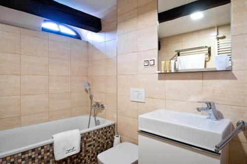 扎泰茨扎泰茨U哈达酒店的一间带水槽、浴缸和卫生间的浴室