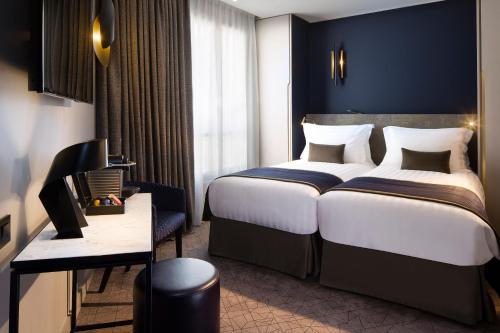 巴黎Le 10 BIS酒店的酒店客房设有一张大床和一张书桌。