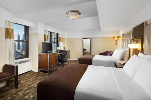 纽约纽约客温德姆酒店的酒店客房配有两张床和一张书桌