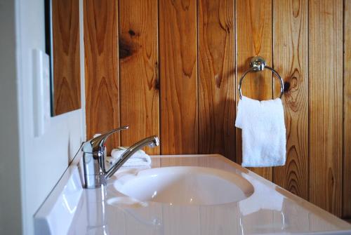 奥阿库尼国王奥阿库尼酒店的浴室设有白色水槽和木墙