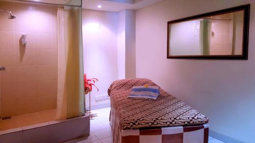 巨港ASTON Palembang Hotel & Conference Centre的带淋浴、床和镜子的浴室