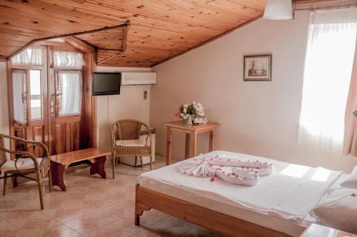 达利安Metin Hotel的一间卧室配有一张床,并在一间客房内配有电视。