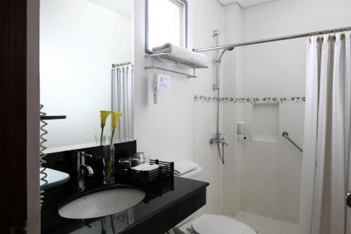 马尼拉Manila Lotus Hotel的白色的浴室设有水槽和淋浴。