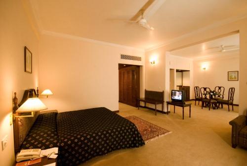 SikaHotel Express Residency-Jamnagar的一间卧室设有一张床和一间客厅。