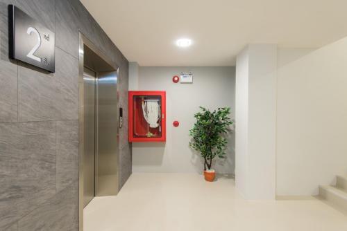 清迈奈普费斯特酒店的走廊上设有红色的门和盆栽植物