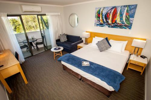 布里斯班曼利匡湖居汽车旅馆 的酒店客房带一张大床和一把椅子