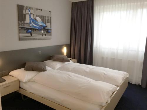 格伦兴格伦兴机场酒店的酒店客房设有两张床和窗户。